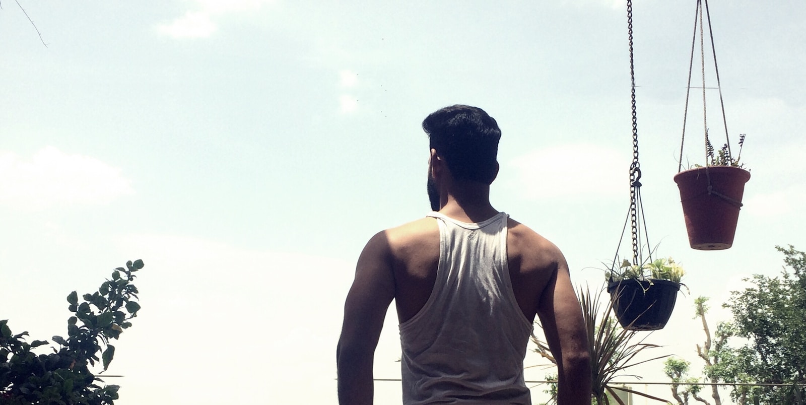 man in white tank top standing